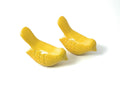Set of two small, yellow, handcrafted bird figurines suitable for tabletop display.