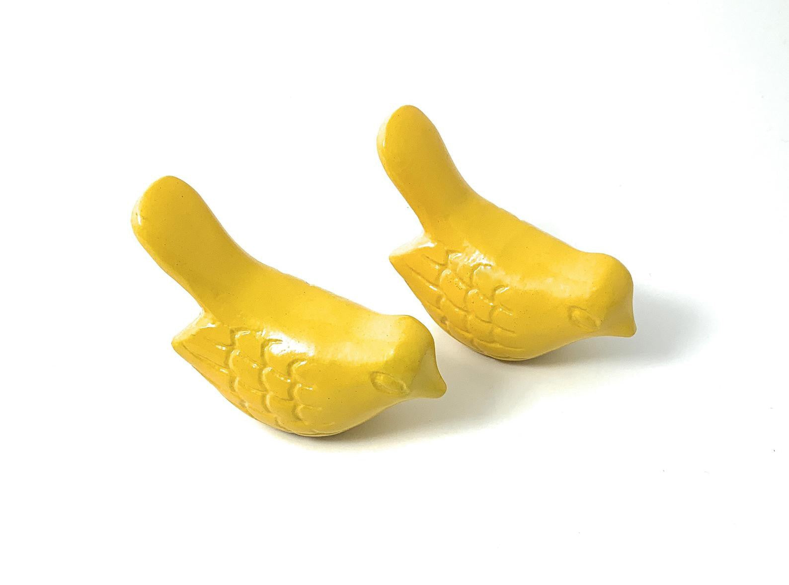Set of two small, yellow, handcrafted bird figurines suitable for tabletop display.