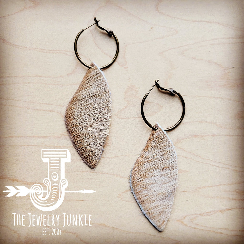 Antique gold hoop earrings featuring natural tan dark hair-on-hide leather dangles on a wooden background