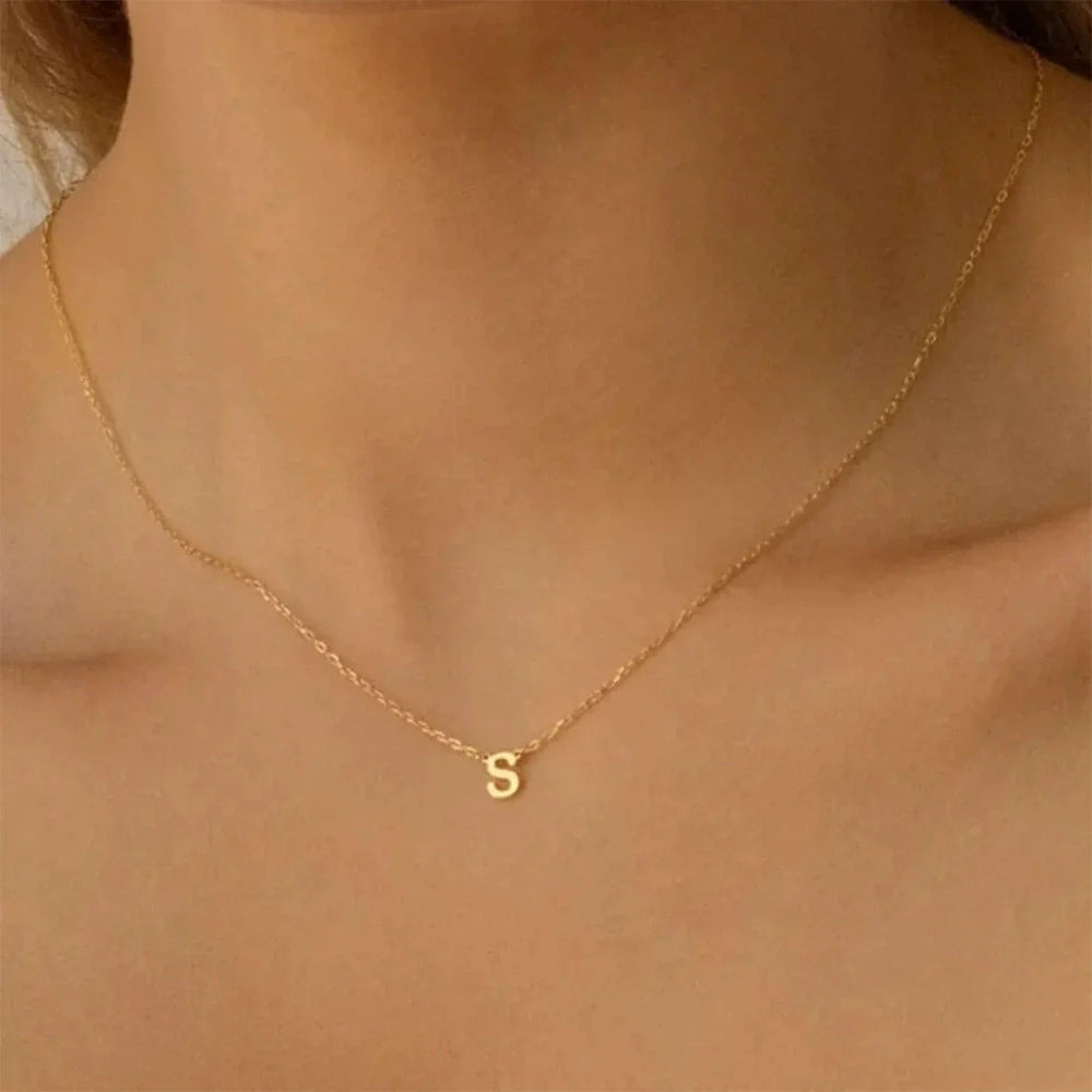 Minimalist gold dainty initial letter necklace worn by a woman