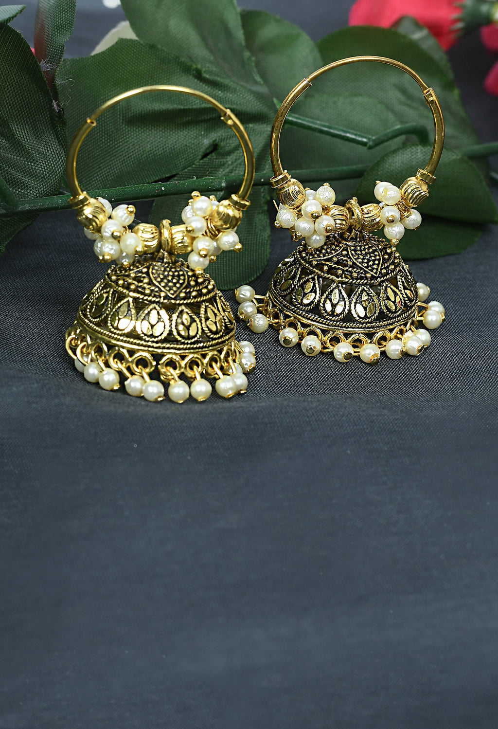 Golden designer Jhumkas with white detailing and traditional drop shape.