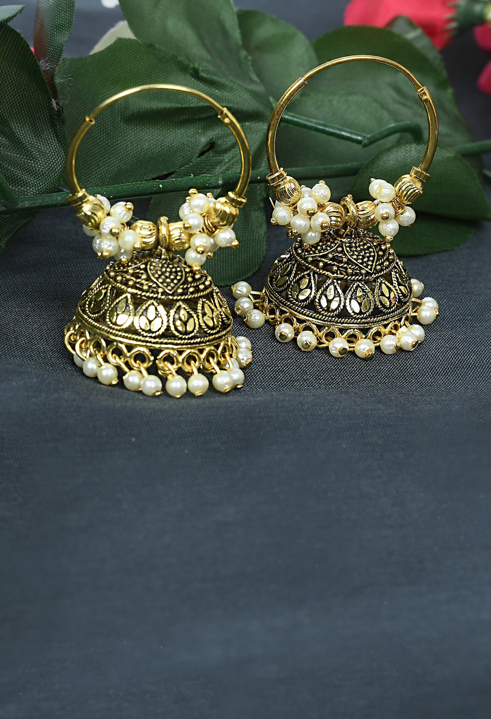 Golden designer Jhumkas with white detailing and traditional drop shape.