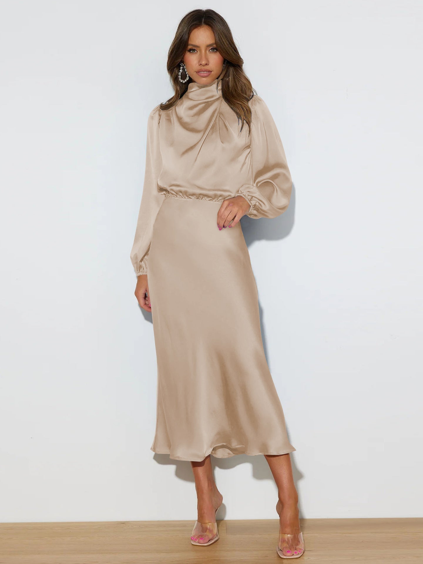 Model wearing a glamorous mid-length satin halterneck dress with long sleeves in solid color