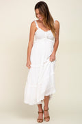 Model wearing a white smocked bodice midi dress with ruffled straps and a tiered skirt.