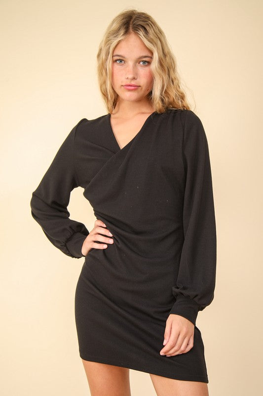 A close-up of a black bodycon mini dress featuring flattering ruched detailing.