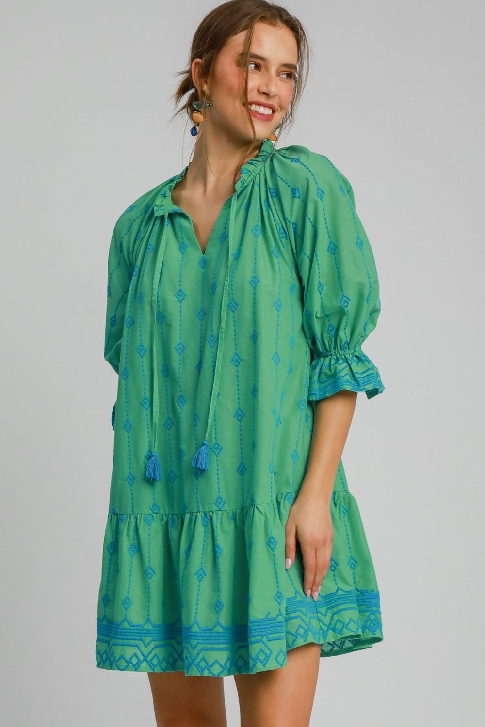 Green and blue mini dress with geometric pattern, tassel embroidery, and ruffled sleeves