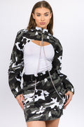 Front view of a woman wearing a camouflage print cropped jacket with silver metal chains and a front zipper.