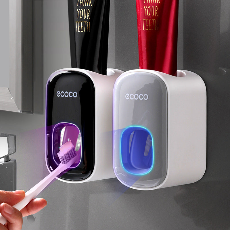 Modern white wall-mounted automatic toothpaste dispenser and cup storage set for bathroom organization