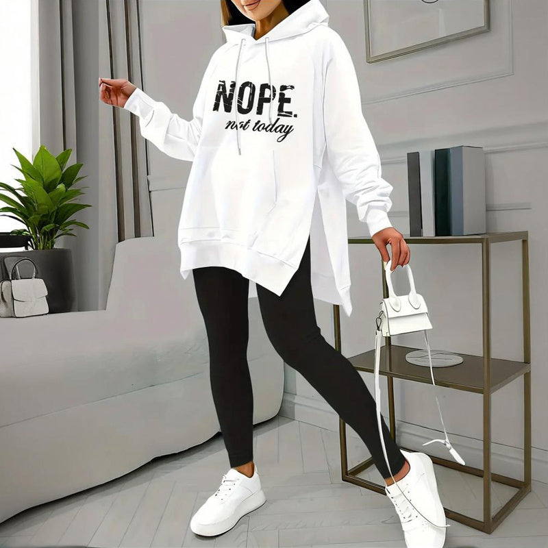 Model wearing a white letter print hooded sweatshirt with black leggings and white sneakers