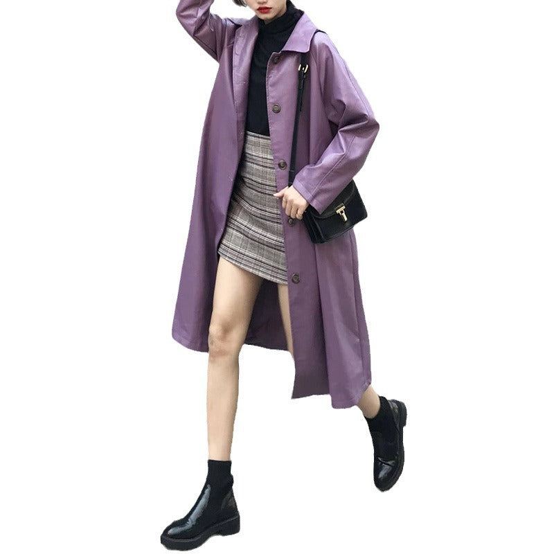 Woman wearing a purple bandage faux leather trench coat in Harajuku style, paired with a black turtleneck, plaid skirt, and black boots.