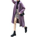 Woman wearing a purple bandage faux leather trench coat in Harajuku style, paired with a black turtleneck, plaid skirt, and black boots.