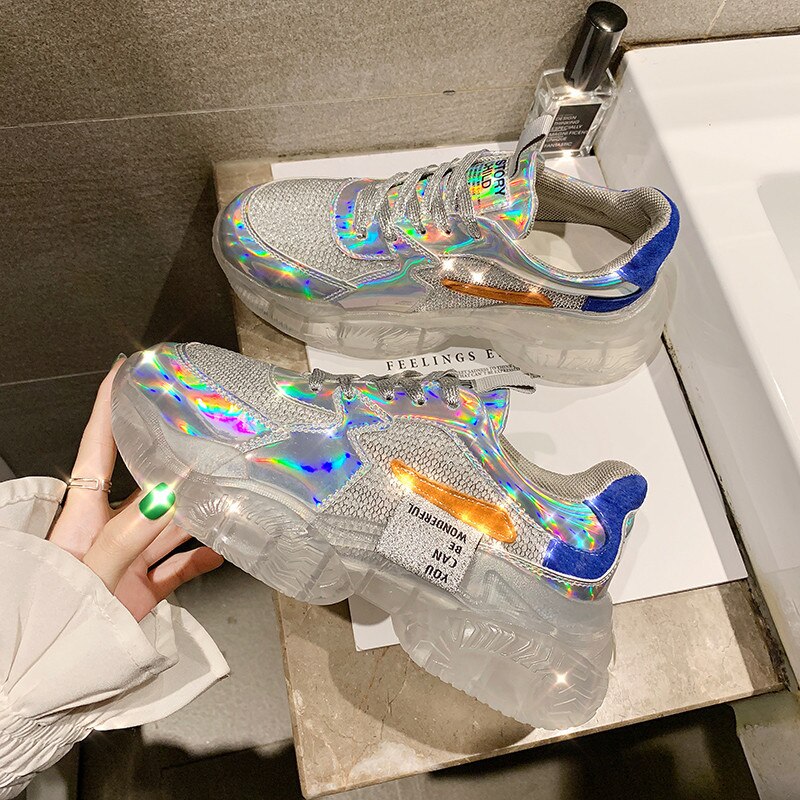 Pair of women's iridescent mesh chunky platform sneakers with clear soles and blue/orange accents.