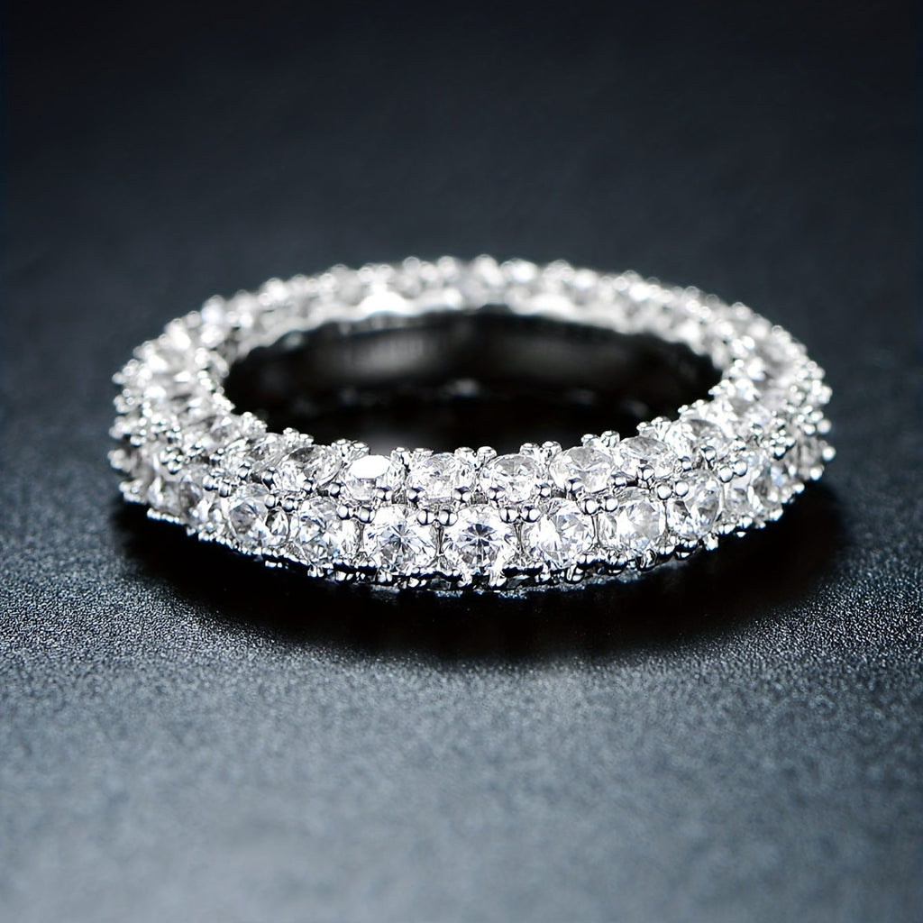 Minimalist three-stone cubic zirconia ring in polished silver finish on a neutral background