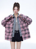 A model wears a women's pink and black plaid oversized long sleeve top with denim patchwork detail, styled with a grey tank top and black shorts against a white background.