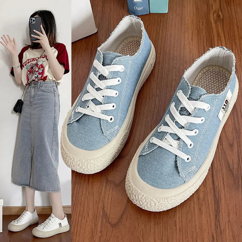 Pair of light blue canvas platform sneakers with thick white soles and white laces, displayed on a wooden surface.