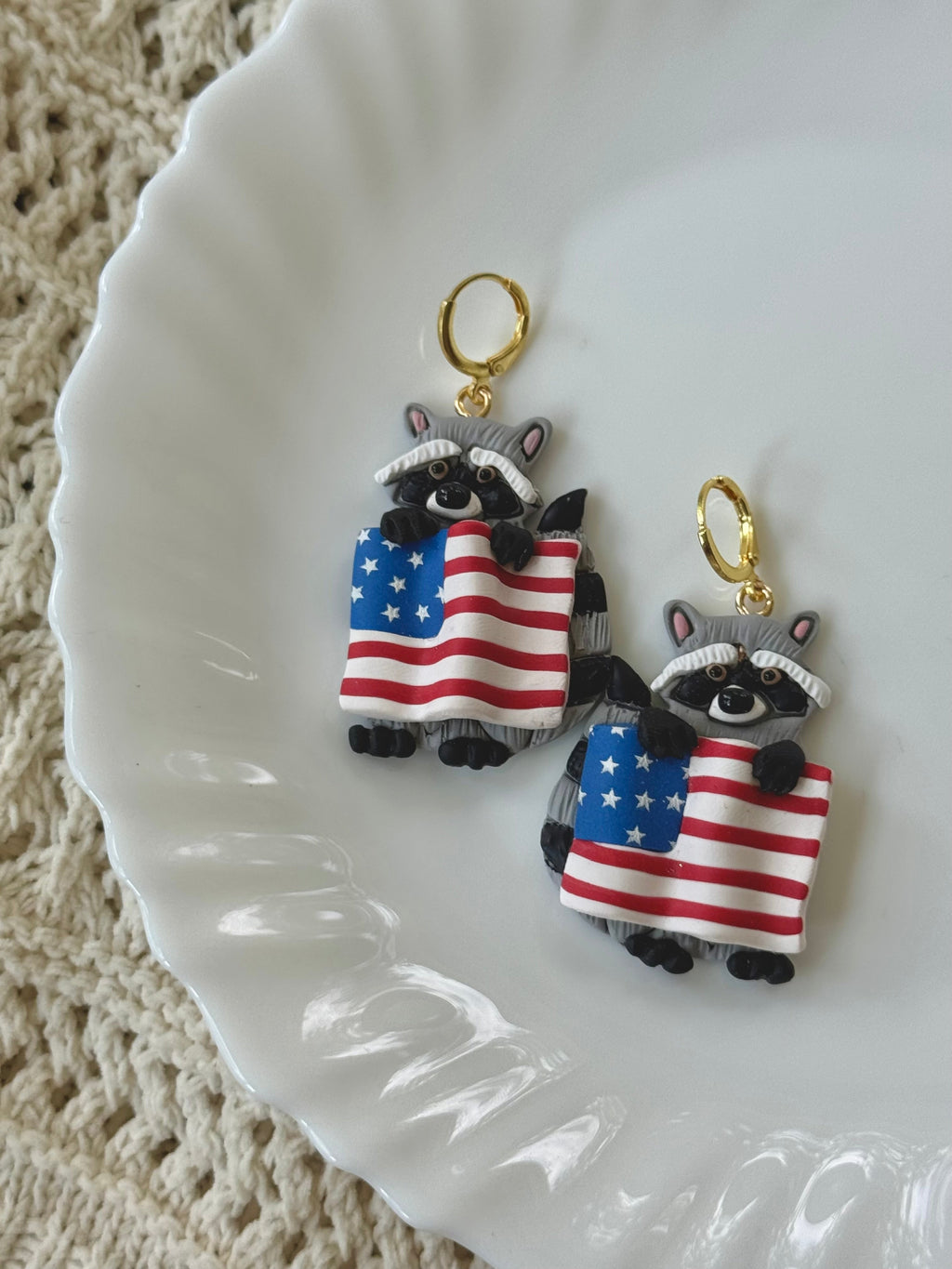 Freedom Bandit earrings with red, white, blue, and grey clay shapes on gold hardware.