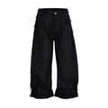 Front view of black waxed baggy jeans with distressed side panels on white background