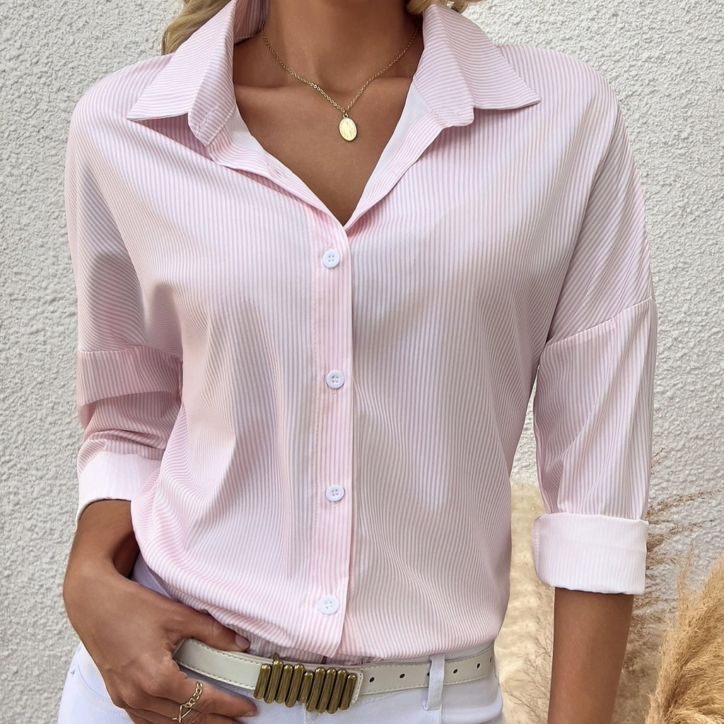 Model wearing a pink and white vertical striped button-down shirt with long sleeves and lapel collar