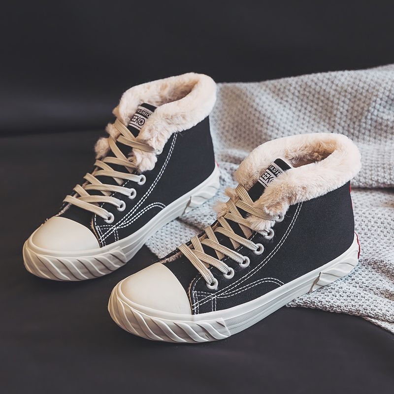 A pair of women's black high-top canvas sneakers with beige fleece lining on a grey textured background.
