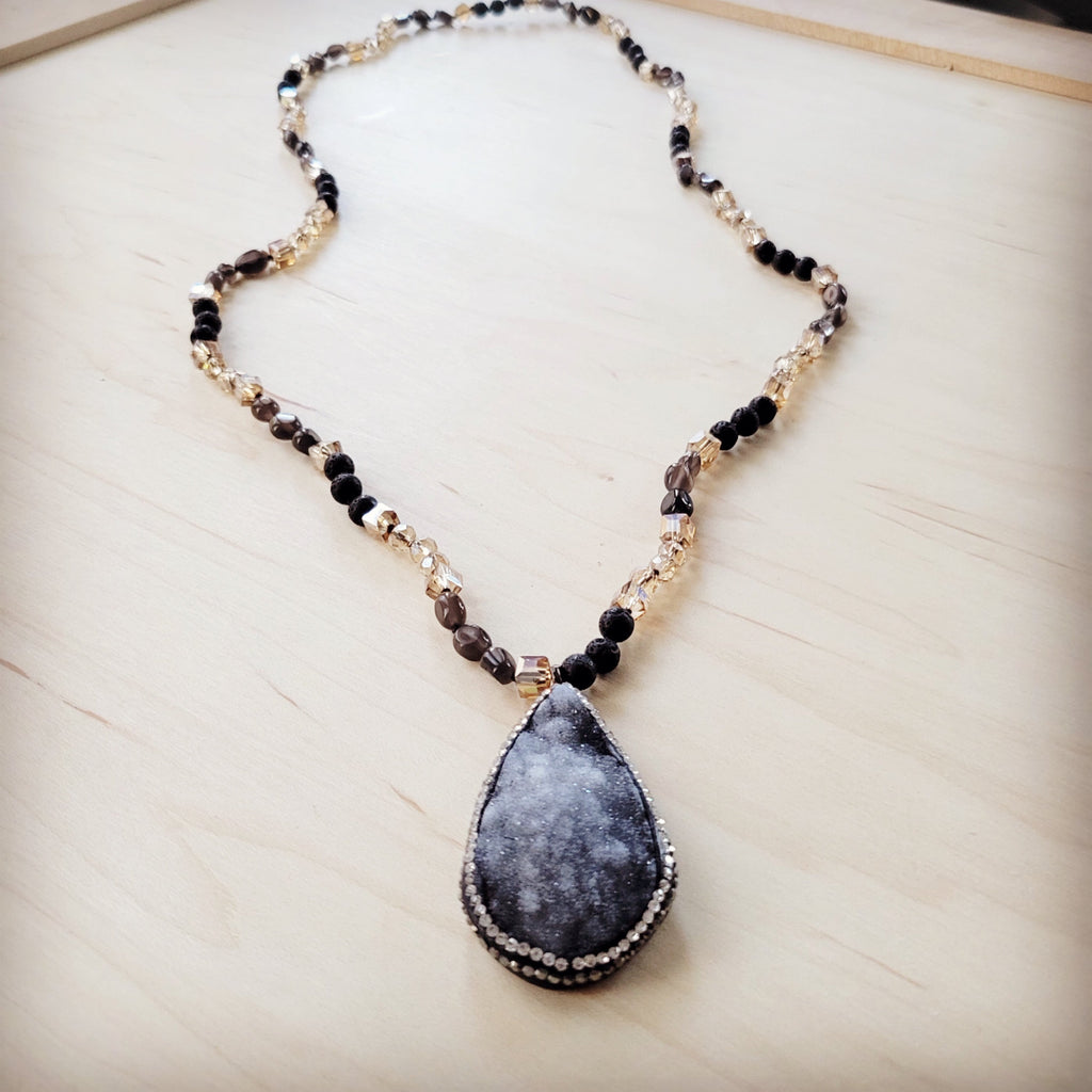 Long black lava bead necklace with a large teardrop shaped druzy pendant and crystal accents