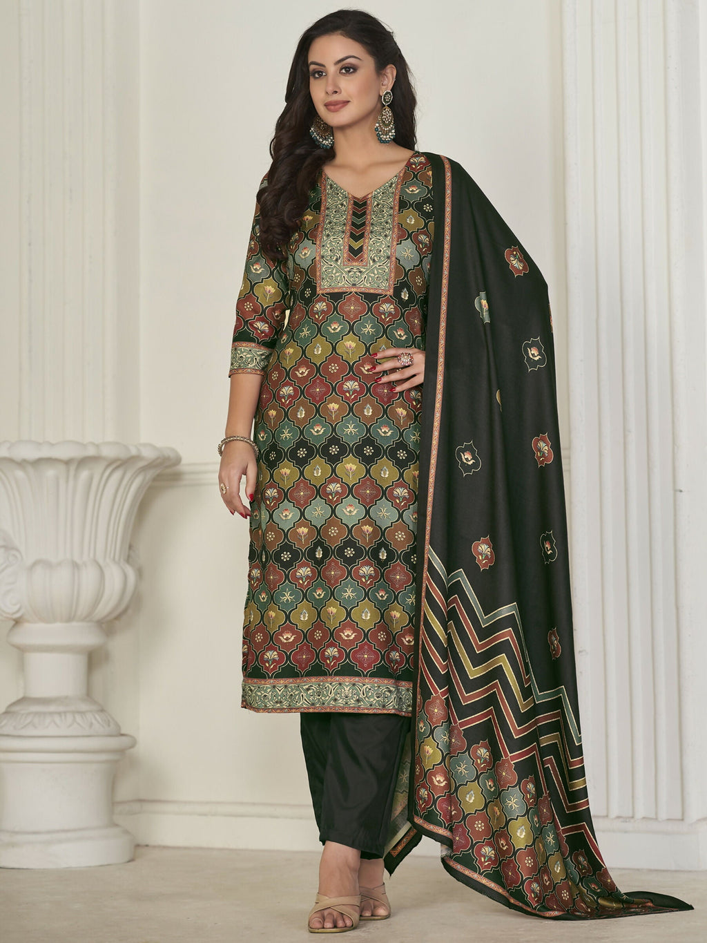 Woman wearing a knee-length dark green, maroon, and mustard geometric pashmina kurta set with matching trousers and dupatta.