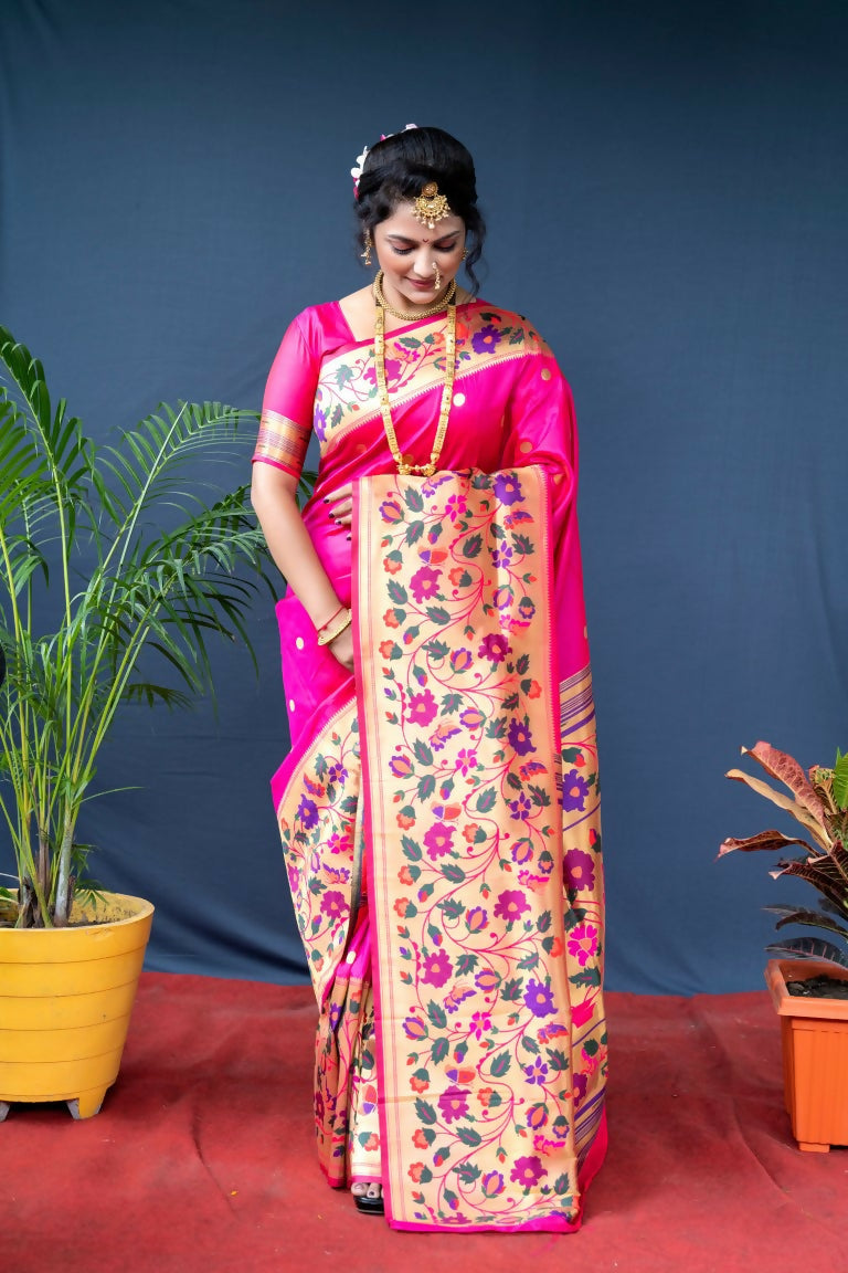 A soft pink Paithani silk saree displaying delicate zari work, draped elegantly on a mannequin.