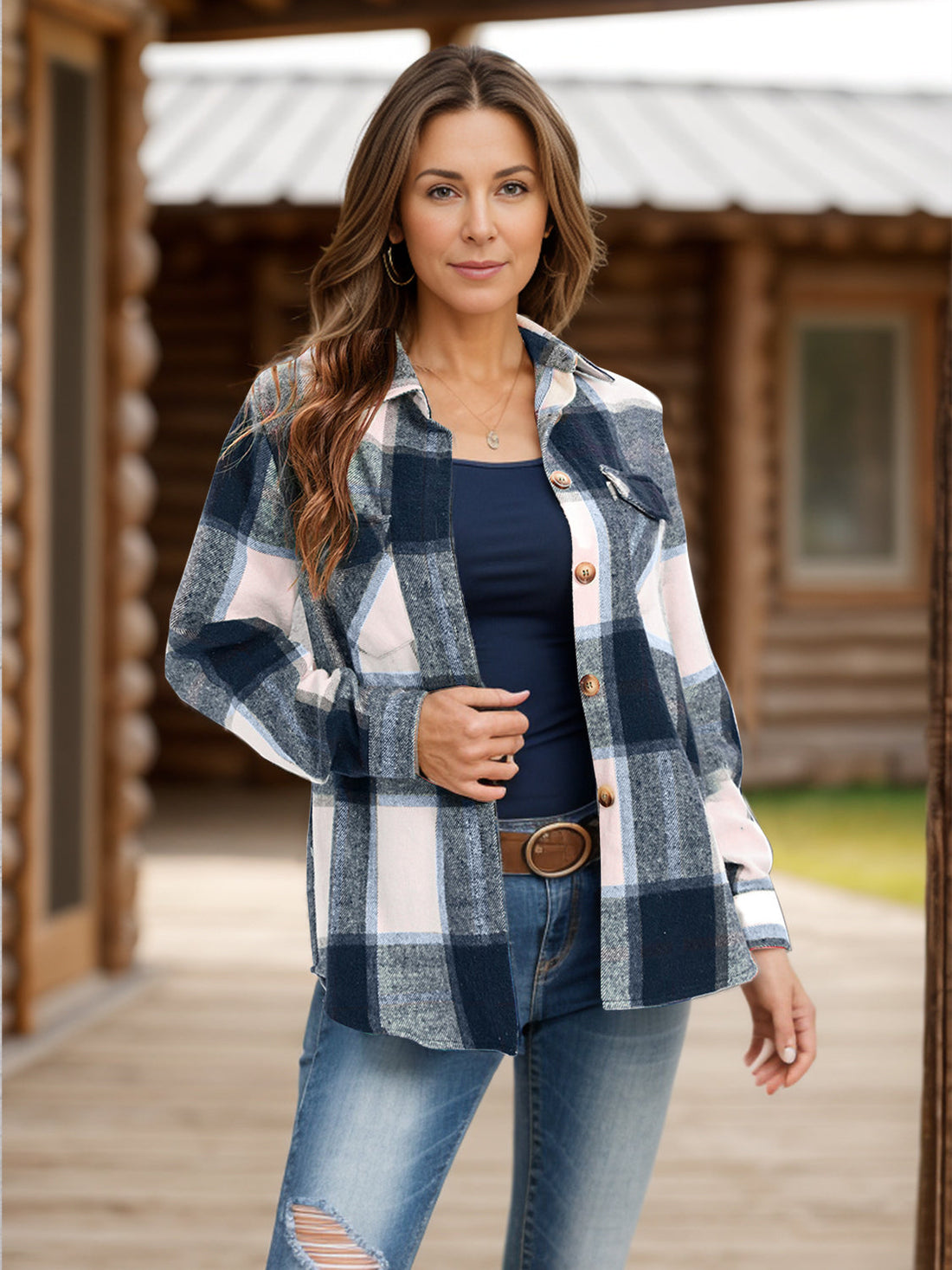 A woman wearing a plaid shacket with a classic collar and chest pockets, styled over a navy top and jeans.