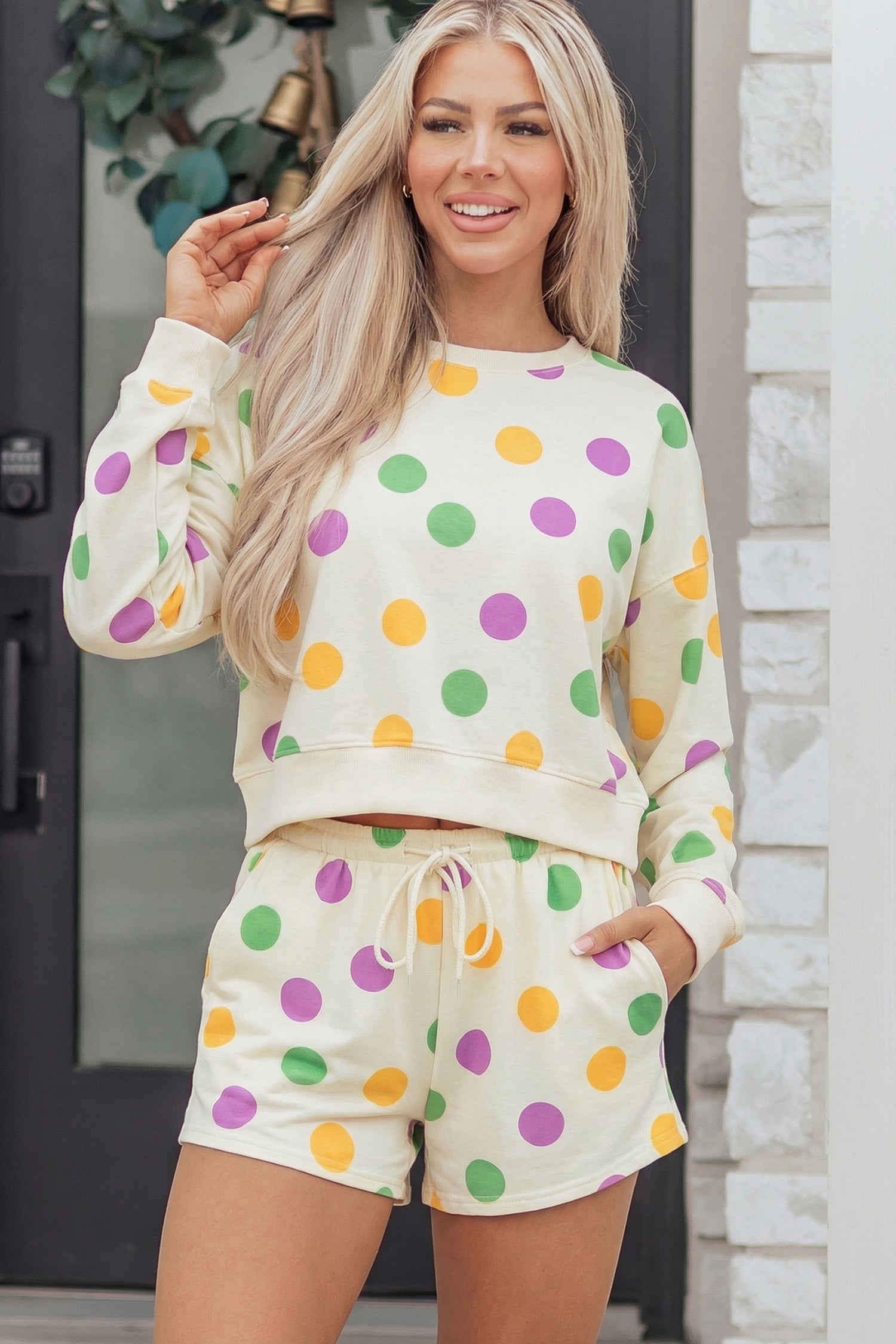 Woman wearing Ember cream knit pullover and matching polka dot drawstring shorts set