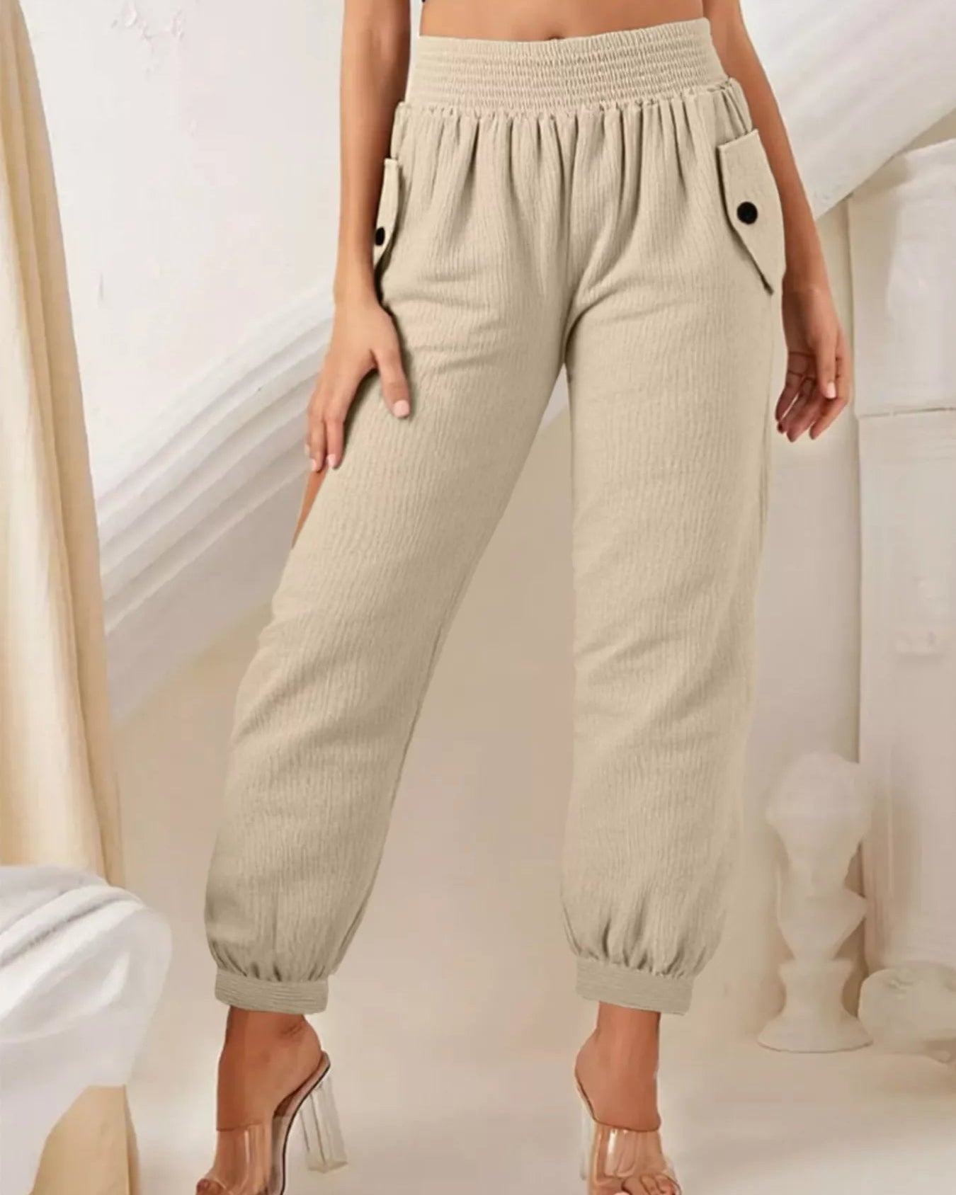 Beige jogger pants worn by a person on a neutral background