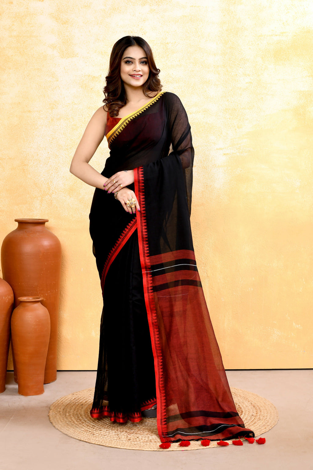 Black handloom cotton saree with intricate embellishments worn as elegant ethnic wear