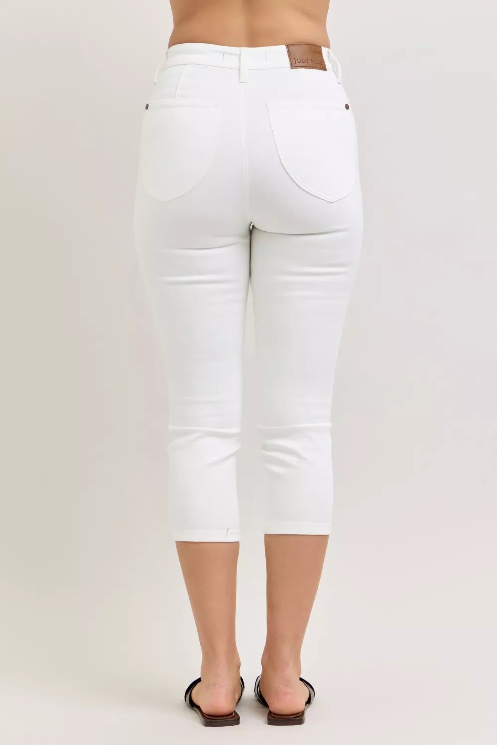 White jeans worn by a person on a white background