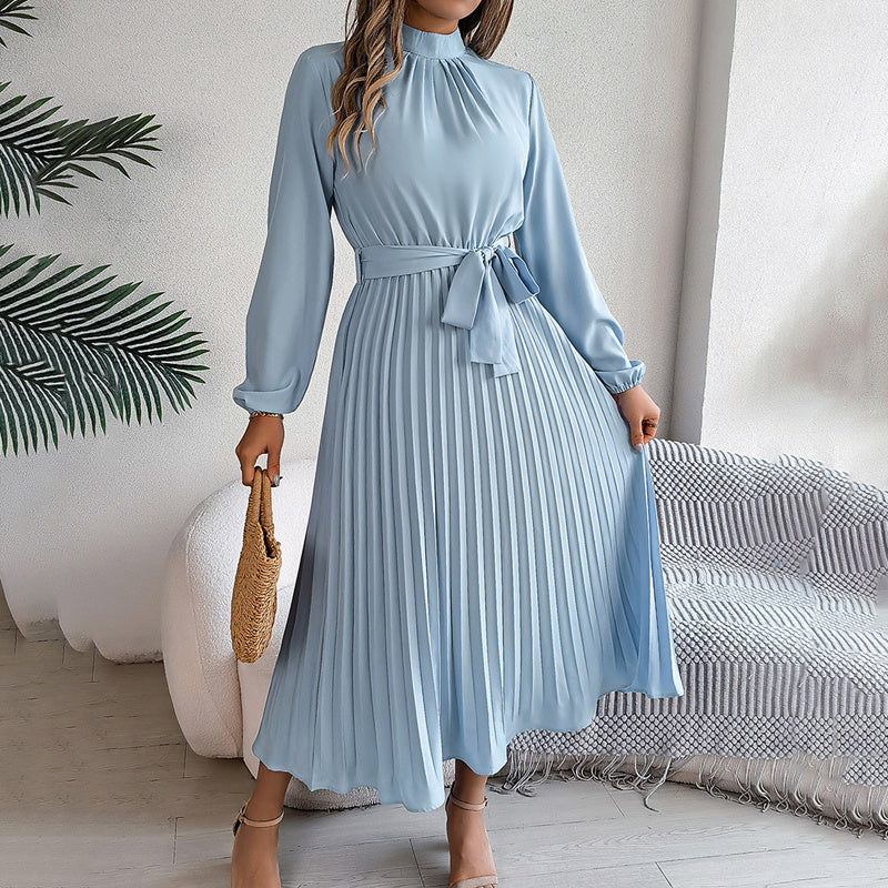 Woman wearing a high neck long sleeve pleated maxi dress in solid color