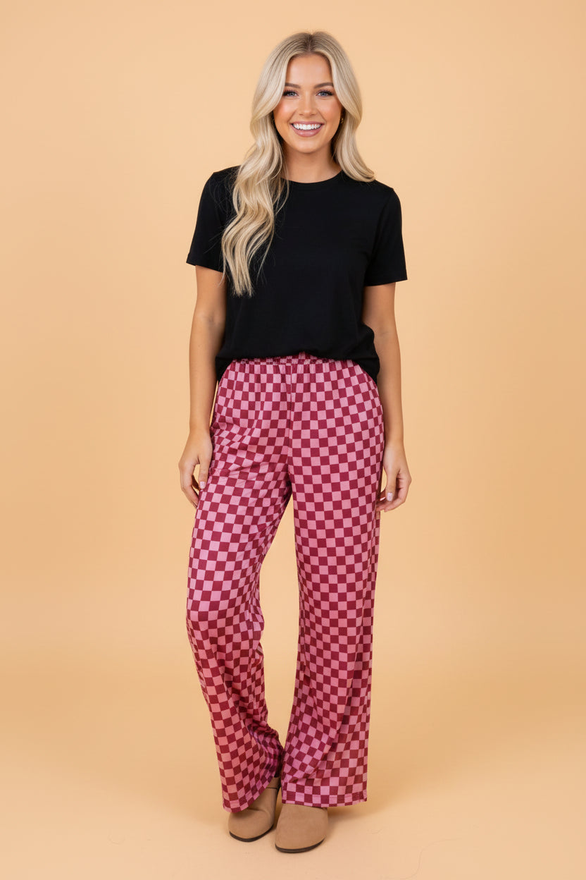 Woman wearing burgundy and light-pink geometric checkerboard print high-waisted wide-leg pants with a relaxed fit