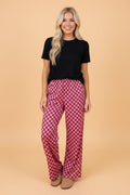Woman wearing burgundy and light-pink geometric checkerboard print high-waisted wide-leg pants with a relaxed fit