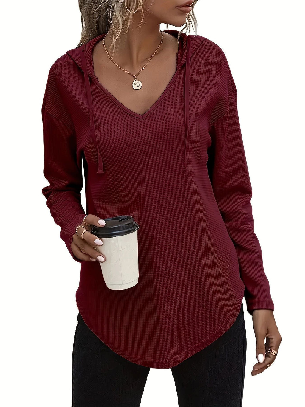V-neck pullover sweater with drawstring hood in solid black and pink knit fabric