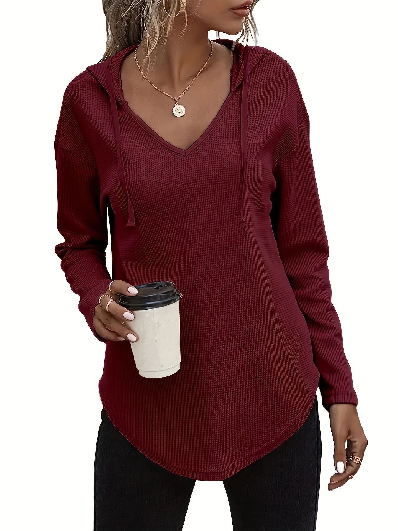 V-neck pullover sweater with drawstring hood in solid black and pink knit fabric