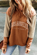 Woman wearing a two-tone Los Angeles graphic hoodie with textured sleeves and V-neckline