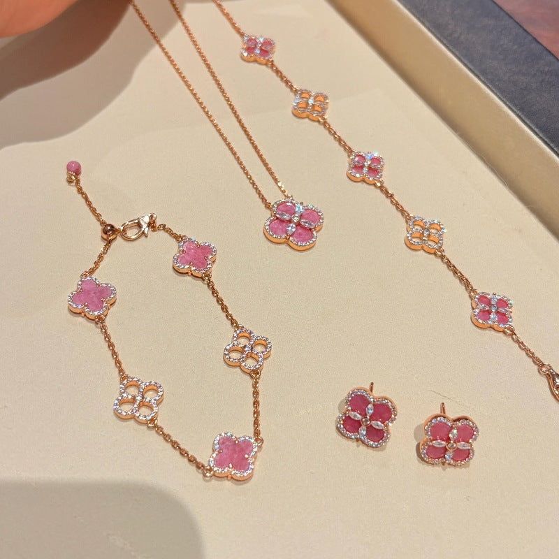 Pink four leaf clover necklace, bracelet, and earring set with gold-tone finish and crystal accents.