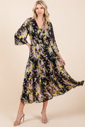 Woman wearing a romantic floral print satin midi dress with smocked bodice and tiered skirt.