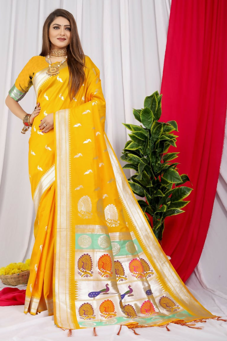 Woman wearing a vibrant yellow Paithani silk saree with intricate gold Zari woven borders and matching blouse.
