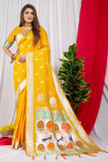 Woman wearing a vibrant yellow Paithani silk saree with intricate gold Zari woven borders and matching blouse.