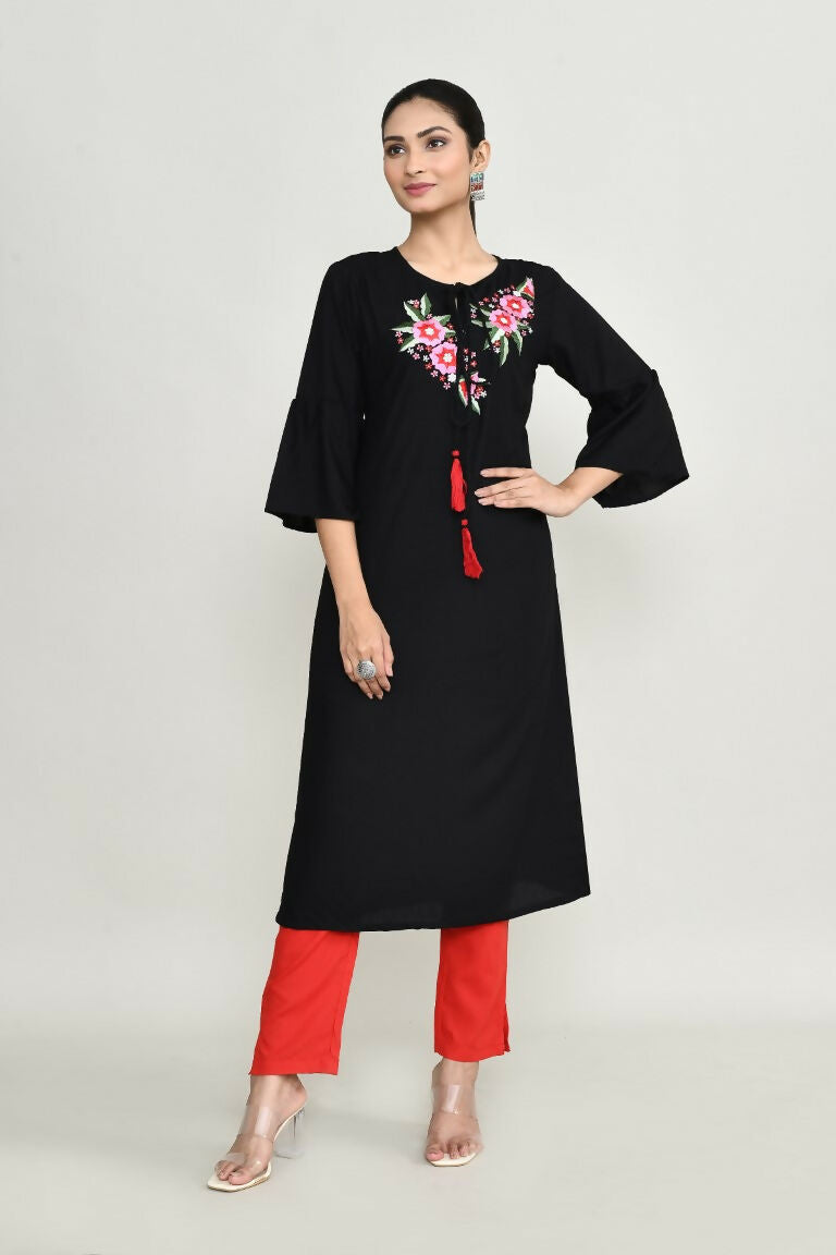 Woman wearing a black rayon tunic with delicate embroidery detailing.