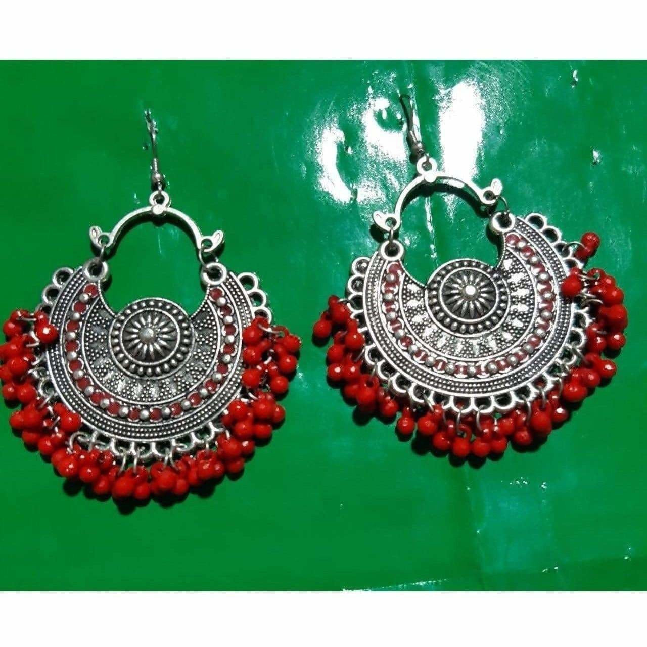 Fancy Chandbali earrings featuring vibrant red pearls and intricate metalwork