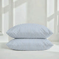 A stack of two soft Australian sateen cotton pillowcases in a bedroom setting