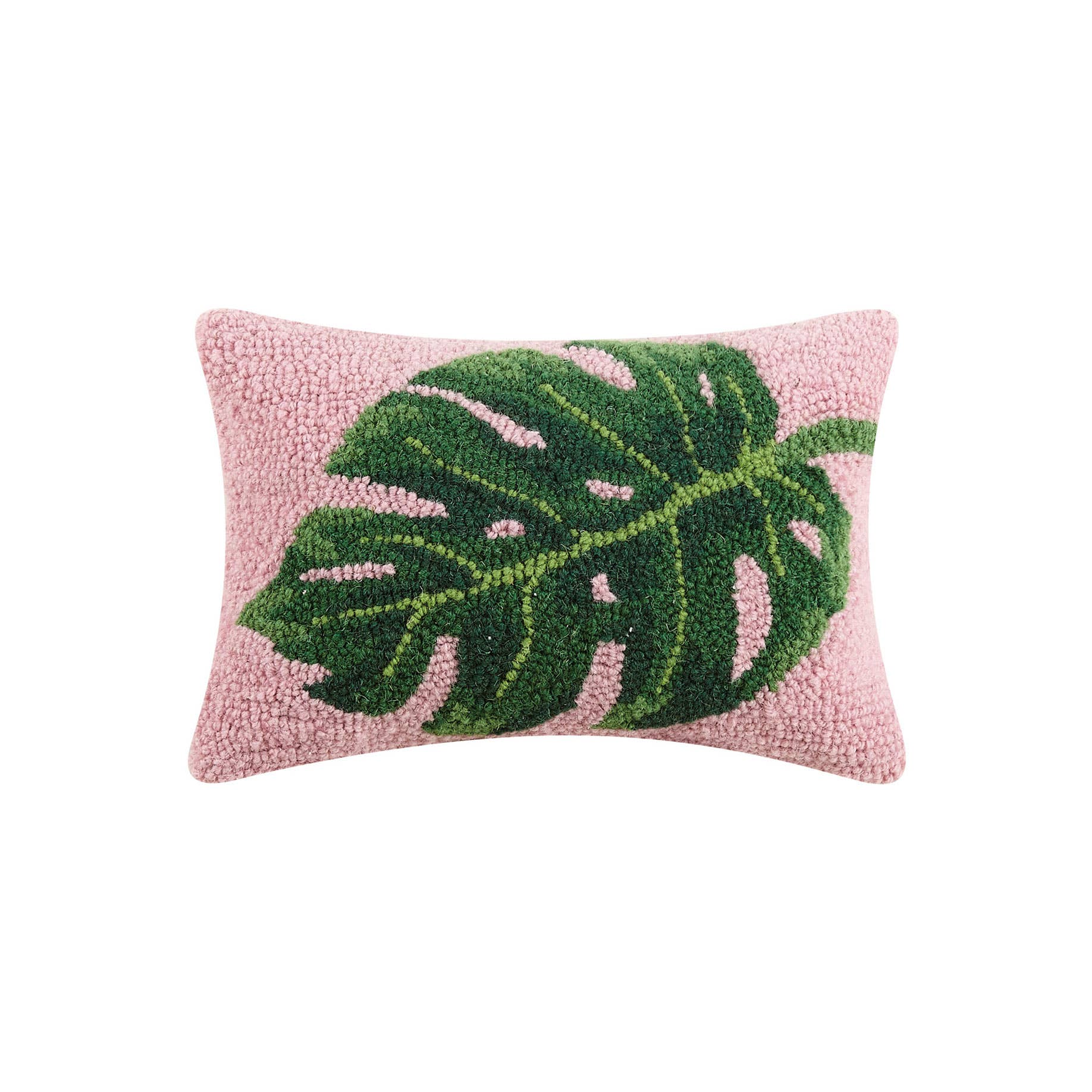 Close up of 12x20 inch palm leaf hook pillow with vibrant pink background and green botanical design on a sofa