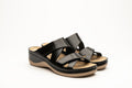 Pair of black leather women's orthopedic slide sandals with dual adjustable velcro straps and tan contoured footbeds.
