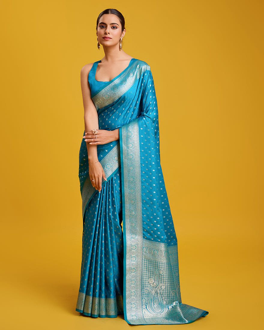 A beautiful Cyan Banarasi silk saree with intricate gold Zari woven work and matching blouse fabric.