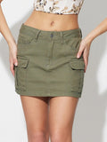 Model wearing an olive green pocketed denim mini skirt, front view showing button closure and cargo pockets.