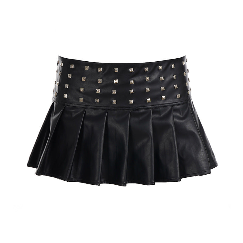 Black faux leather pleated mini skirt with silver rivet detailing on the waistband, shown on a white background and worn by a model.