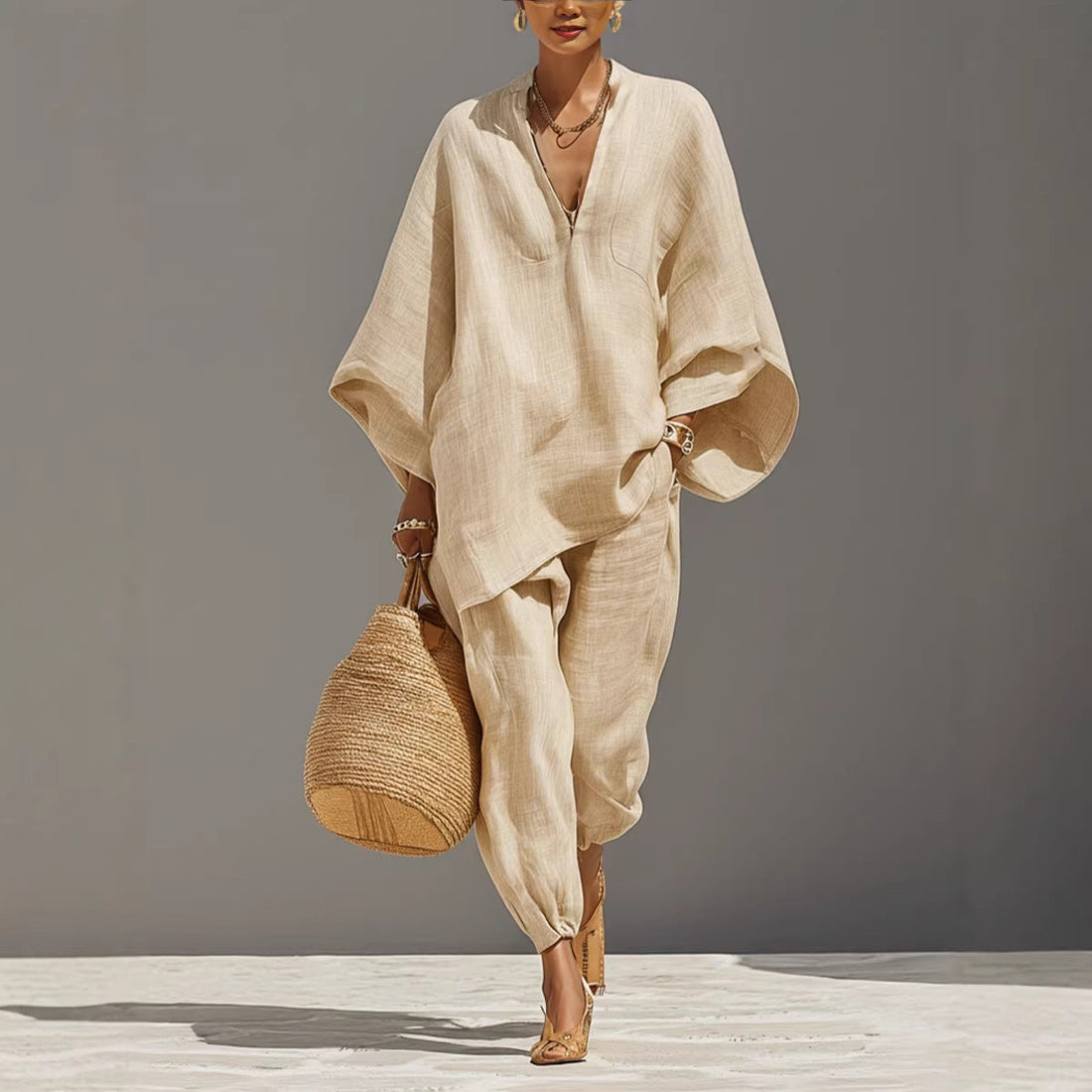 A woman wearing a casual beige two-piece shirt and jogger set with a straw bag.